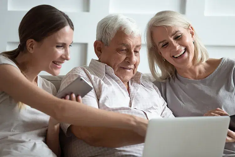 Familia con adulto mayor revisan su afiliación desde computador