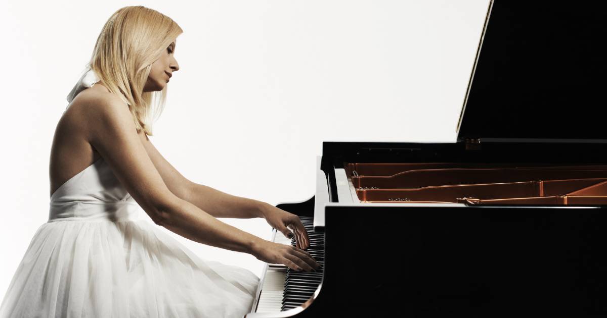 Valentina Lisitsa con un vestido blanco, tocando el piano. 